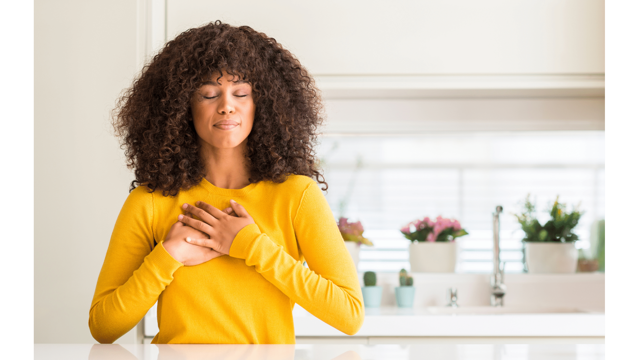 young girl with eyes closed and hands folded across her heart