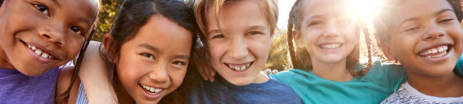 five happy smiling kids with varying ethnicity