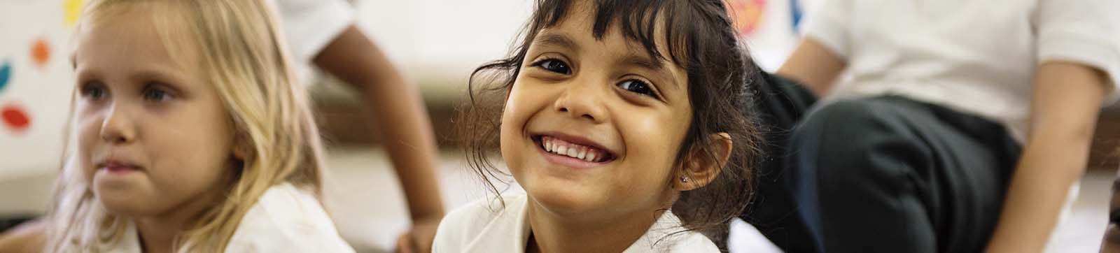 smiling young girl with another girl in background